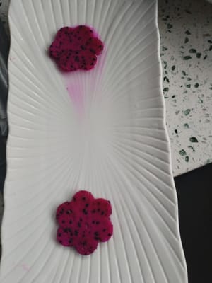 把火龙果切片用模具切出火龙果模型装盘备用。