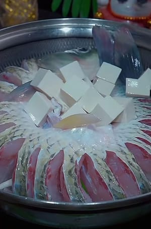 Luego coloque una carpa herbívora remojada en cerveza en forma de arco y luego corte el tofu en cubos pequeños y viértalos en el medio de la forma de arco de la carpa herbívora.