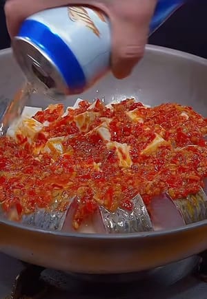 Verter 50 gramos de salsa de pimienta picada sobre el pescado. Añadir media botella de cerveza y una cucharada de salsa de soja ligera.