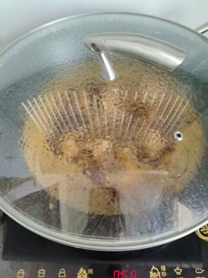 Ajoutez le gingembre, l'ail haché, un peu de sel et une demi-bouteille de bière pour attendrir la viande, couvrez et laissez mijoter 3 à 4 minutes.
