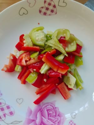 Coupez les poivrons verts et rouges en deux, coupez-les en lanières épaisses, puis coupez-les en petits morceaux.