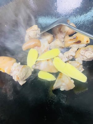 炒猪手上色
锅烧热加两勺食用油,倒入猪手翻炒到表面有点焦黄,加入姜片炒出香味,再从锅边淋入一勺料酒,接着依次加两勺生抽、一勺蚝油、一勺老抽,翻炒均匀。
炒到焦黄能让猪手更香,先加姜片炒香再淋料酒,能让姜香和酒香融合,更好地去掉腥味;生抽提鲜、蚝油增味、老抽上色,一步到位让猪手有底味又好看。