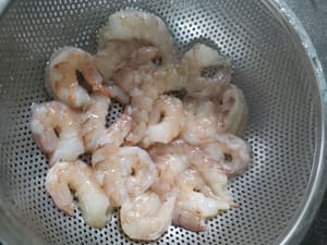 Anschließend die Garnelen sauber waschen (die Garnelenköpfe entfernen, dann die Haut abziehen und den Rücken aufschneiden, dann sauber waschen und abtropfen lassen)