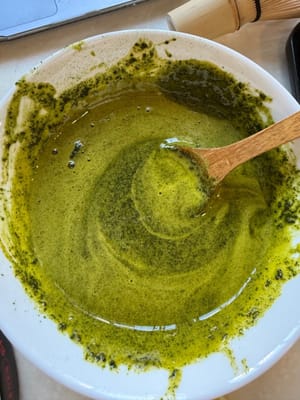 Ayak 10 gram bubuk matcha (disarankan untuk mencampur bubuk matcha terlebih dahulu dengan susu panas), lalu aduk rata.