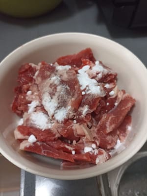 Das Rindfleisch in dünne Scheiben oder je nach Geschmack schneiden, dann 1/2 EL Natron dazugeben und verkneten, bis alles gut vermischt ist.
