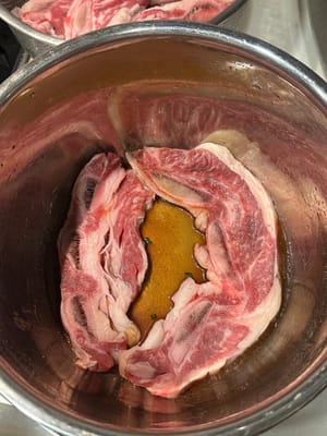 In un contenitore per la marinatura, mettere uno strato di salsa sul fondo e adagiarvi bene le costine