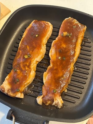 Dopo la marinatura, mettere le costine su una griglia prima di accendere il fuoco. Versare un po' di salsa sulle costine