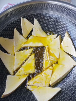 Potong 200 gram tahu menjadi potongan segitiga dan goreng dalam minyak.
