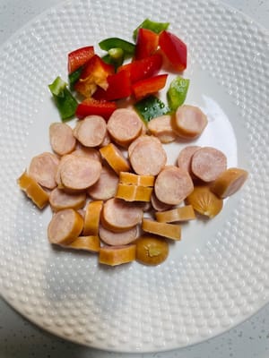 Hidangan Pendamping Seru: Potong sosis asap menjadi irisan tipis, dan potong dadu paprika hijau dan merah. Masukkan semuanya ke dalam mangkuk dan sisihkan. Kelihatannya dan rasanya enak sekali!