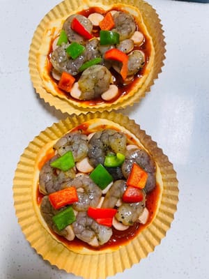 Pizza Sosis dan Udang Cara Merakit: Oleskan saus pizza tebal-tebal pada alas pizza mini, beri topping sosis, udang, dan paprika hijau dan merah, lalu tutupi dengan tumpukan keju mozzarella yang tebal. Toppingnya sangat melimpah hingga hampir tumpah!