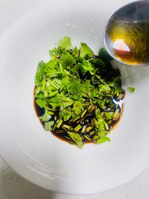 Koriander waschen und hacken, 3 Esslöffel helle Sojasauce hinzufügen und gut vermischen.