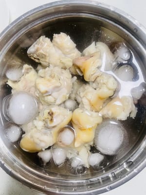 Die gekochten Schweinsfüße herausnehmen, kurz abspülen und in abgekochtem, kaltem Wasser mit Eiswürfeln einlegen. Nach dem Einlegen sind sie besonders knusprig.