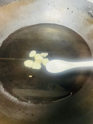 In einem separaten Topf ausreichend Wasser, einen Löffel Salz, geschnittenen Ingwer und zwei Esslöffel Kochwein geben. Die Schweinsfüße hinzufügen und nach dem Aufkochen des Wassers 35 Minuten bei schwacher Hitze köcheln lassen.