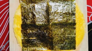 Lay a layer of seaweed sheets, then a layer of shrimp paste, and after spreading the shrimp paste evenly, add a layer of shredded radish.