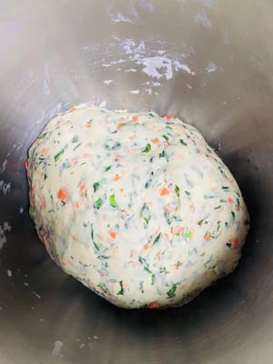 Preparar y mezclar los ingredientes: Colocar las zanahorias picadas y las hojas de coliflor en un bol. Añadir 1,5 g de bicarbonato (omitir si no le importa la apariencia), 4 g de sal, 10 g de azúcar y 4 g de levadura (la sal aporta textura, el azúcar favorece la fermentación).
Añadir agua y amasar: Añadir 60 g de agua inicialmente y ajustar los 40 g restantes según el grado de sequedad de las hojas de coliflor (mantener la cantidad total de agua en torno a 100 g). Amasar bien hasta obtener una masa suave (criterios: la masa debe ser fina y elástica al tacto, no pegajosa a las manos ni a la sartén, y brillante y lisa). Colocar en un lugar a 30 °C (140 °F), tapar y dejar levar hasta que doble su volumen.