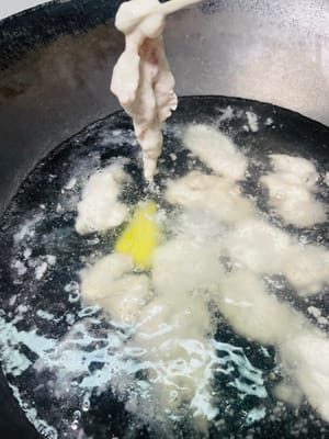 Poner abundante agua en una olla, añadir 5 g de sal, pimienta y un trozo de jengibre. Cuando el agua esté a punto de hervir (burbujeando, pero sin llegar a hervir), separar los trozos de carne rebozados y echarlos a la olla uno a uno. Una vez que los trozos de carne estén cuajados, presionarlos con cuidado; si suben a la superficie, cocinar durante 3 minutos más.