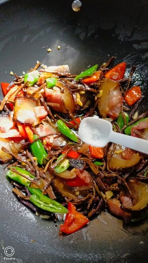 撒上少许食盐和备好的大葱继续翻炒均匀，出锅盛碟