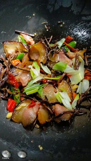撒上少许食盐和备好的大葱继续翻炒均匀，出锅盛碟
