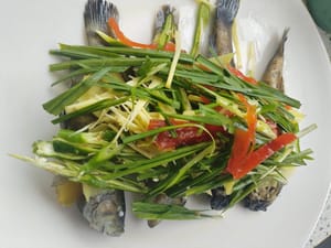 在魚上面鋪上青紅辣椒絲，薑絲。