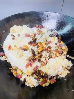 Den gedämpften Klebreis und die restlichen Zutaten in einen Topf geben, kurz anbraten und dann 1 Esslöffel helle Sojasauce, 1 Teelöffel Salz und 1 Esslöffel Austernsauce zum Würzen hinzufügen. Zum Schluss mit gerösteten Erdnüssen und gehackten Frühlingszwiebeln bestreuen, gut vermischen und genießen!