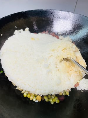 Den gedämpften Klebreis und die restlichen Zutaten in einen Topf geben, kurz anbraten und dann 1 Esslöffel helle Sojasauce, 1 Teelöffel Salz und 1 Esslöffel Austernsauce zum Würzen hinzufügen. Zum Schluss mit gerösteten Erdnüssen und gehackten Frühlingszwiebeln bestreuen, gut vermischen und genießen!