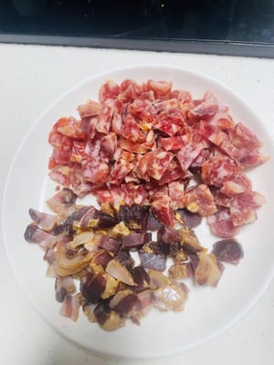 Ich habe 750 g Klebreis mit 4 chinesischen Würsten und etwa 100 g gepökeltem Schweinefleisch verwendet, alles gewürfelt und beiseitegestellt.