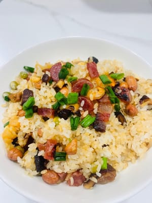 Den gedämpften Klebreis und die restlichen Zutaten in einen Topf geben, kurz anbraten und dann 1 Esslöffel helle Sojasauce, 1 Teelöffel Salz und 1 Esslöffel Austernsauce zum Würzen hinzufügen. Zum Schluss mit gerösteten Erdnüssen und gehackten Frühlingszwiebeln bestreuen, gut vermischen und genießen!