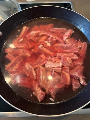 Coupez le bœuf en morceaux, mettez-les dans de l’eau froide et portez à ébullition à feu vif.