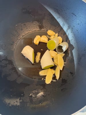 Ajouter les oignons verts, le gingembre et l’ail à l’huile froide et faire sauter à feu vif.