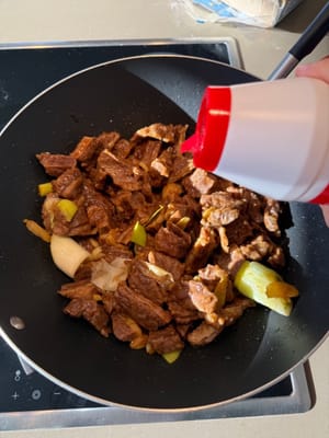 Versez un filet de sauce soja claire sur le bord de la poêle, salez et faites sauter pendant deux minutes.