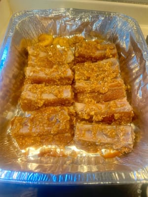 Once the pork is done marinating, transfer onto an aluminium baking tray and spray with oil on both sides