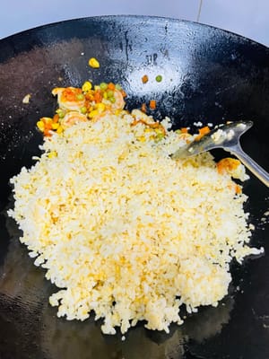 接著倒入炒好的蝦米炒勻, 倒入蛋液飯,翻炒均勻。