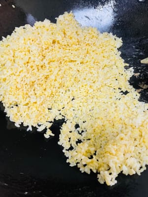 炒蛋液飯:熱鍋放一匙油,倒入蛋液冷飯翻炒,炒至米飯粒粒分明、散發蛋香 。