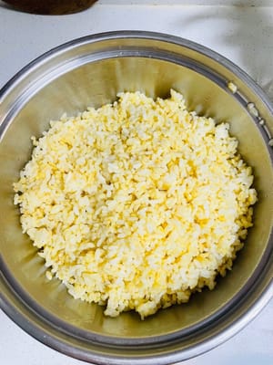 Rührei-Reis: Einen Löffel Öl in einer Pfanne erhitzen, die Eiermischung hinzufügen und unter Rühren braten, bis die Reiskörner deutlich zu erkennen sind und das Aroma des Eies freigesetzt wird.