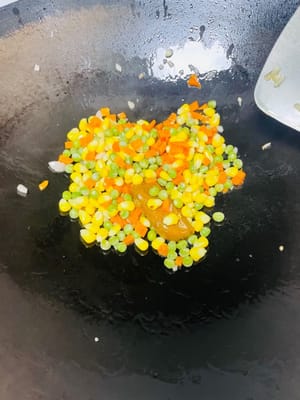 Gemüse anbraten und würzen: Etwas Öl im Wok erhitzen und gehackte Zwiebeln darin anbraten, bis sie duften. Das blanchierte Gemüse dazugeben und mitbraten. Bei Verwendung von Currypaste diese jetzt dazugeben und köcheln lassen, bis sie geschmolzen ist.
