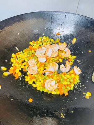 接著倒入炒好的蝦米炒勻, 倒入蛋液飯,翻炒均勻。