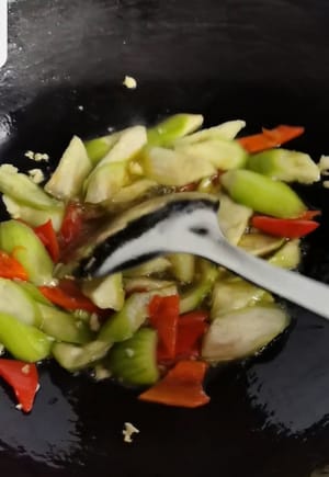 蒜末出香味後放入絲瓜與辣椒翻炒一分鐘。