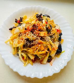 After the vegetables are mixed evenly, add the green onion, sesame oil, pepper oil, and red sesame oil, and stir gently two or three times. Sprinkle an appropriate amount of sesame seeds on the dish and serve.