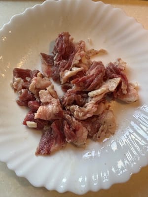 Start by marinating the sliced beef with salt, black pepper and a bit of oil