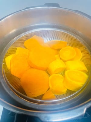 さつまいもの皮をむき、厚めにスライスします。鍋で蒸し、中まで火が通るまで（箸で簡単に刺せるくらい）蒸します。私は圧力鍋を使い、圧力を抜いてから10分ほど蒸しました。