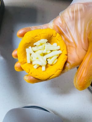 さつまいも生地約50gに、もち米のおにぎりのようにチーズフィリングを包み、ボール状に丸めてから、スクレーパーまたは平らな皿を使用して小さな正方形、または好きな形に押します（正方形を作りたい場合は、作り方をビデオで見ることができます。とても簡単です）。