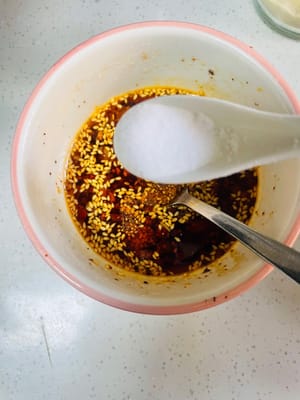 Aggiungere 3 cucchiai di salsa di soia chiara, 5 cucchiai di aceto invecchiato, 1 cucchiaio di zucchero bianco, 1 cucchiaio di sale, 1 cucchiaio di essenza di pollo e 1 cucchiaio di pepe di Sichuan in polvere. Mescolare bene e l'aroma si sprigionerà immediatamente.