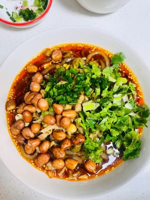 Versare i noodles di riso cotti in una ciotola, guarnire con ravanelli secchi saltati in padella e fagioli dall'occhio sottaceto, cospargere con coriandolo e cipollotti tritati e aggiungere qualche arachidi.