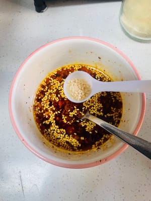 Aggiungere 3 cucchiai di salsa di soia chiara, 5 cucchiai di aceto invecchiato, 1 cucchiaio di zucchero bianco, 1 cucchiaio di sale, 1 cucchiaio di essenza di pollo e 1 cucchiaio di pepe di Sichuan in polvere. Mescolare bene e l'aroma si sprigionerà immediatamente.