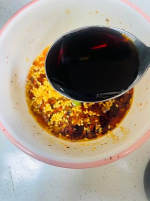 Aggiungere 3 cucchiai di salsa di soia chiara, 5 cucchiai di aceto invecchiato, 1 cucchiaio di zucchero bianco, 1 cucchiaio di sale, 1 cucchiaio di essenza di pollo e 1 cucchiaio di pepe di Sichuan in polvere. Mescolare bene e l'aroma si sprigionerà immediatamente.