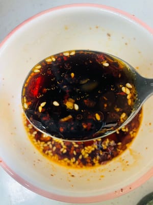 Aggiungere 3 cucchiai di salsa di soia chiara, 5 cucchiai di aceto invecchiato, 1 cucchiaio di zucchero bianco, 1 cucchiaio di sale, 1 cucchiaio di essenza di pollo e 1 cucchiaio di pepe di Sichuan in polvere. Mescolare bene e l'aroma si sprigionerà immediatamente.