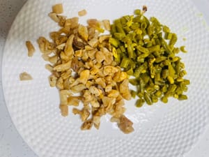 Saltare gli ingredienti: nella stessa padella usata per friggere l'olio, soffriggere prima il ravanello essiccato finché l'acqua non evapora e rimuoverla; quindi soffriggere i fagioli dall'occhio sottaceto finché l'acqua non evapora. Assicurarsi di soffriggerli separatamente, altrimenti i sapori si mescoleranno e il piatto non sarà altrettanto profumato.