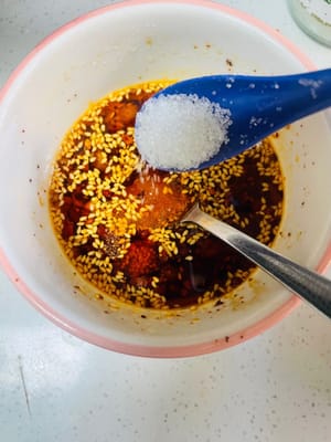 Aggiungere 3 cucchiai di salsa di soia chiara, 5 cucchiai di aceto invecchiato, 1 cucchiaio di zucchero bianco, 1 cucchiaio di sale, 1 cucchiaio di essenza di pollo e 1 cucchiaio di pepe di Sichuan in polvere. Mescolare bene e l'aroma si sprigionerà immediatamente.