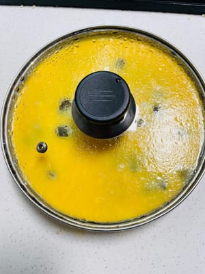 4. Cubra el recipiente con film transparente (o una tapa de vidrio) y perfore varios agujeros pequeños con un palillo. Una vez que el agua de la olla hierva, coloque el recipiente dentro. Si usa film transparente: cocine al vapor a fuego medio durante 8 minutos, luego apague el fuego y deje reposar 2 minutos. Si usa una tapa de vidrio: cocine al vapor durante 10 minutos, luego apague el fuego y deje reposar 1 minuto. Retire la tapa y agítela; la mezcla de huevo debe estar cuajada, pero sin grumos.