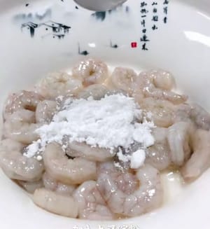 處理好的蝦子撒少許鹽，少許胡椒粉，一個蛋清，一茶勺料酒，攪拌均勻，加一茶勺玉米澱粉，戴手套抓拌均勻。